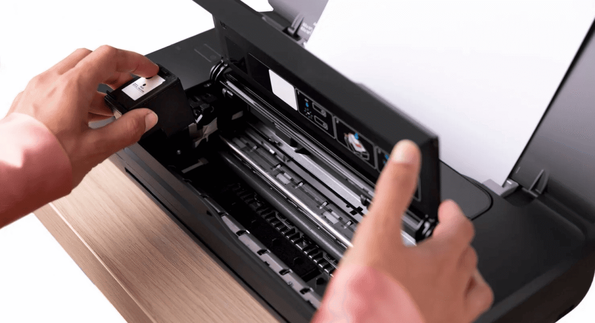 Person installing a black ink cartridge into an inkjet printer, buying office printer supplies online in Sri Lanka.