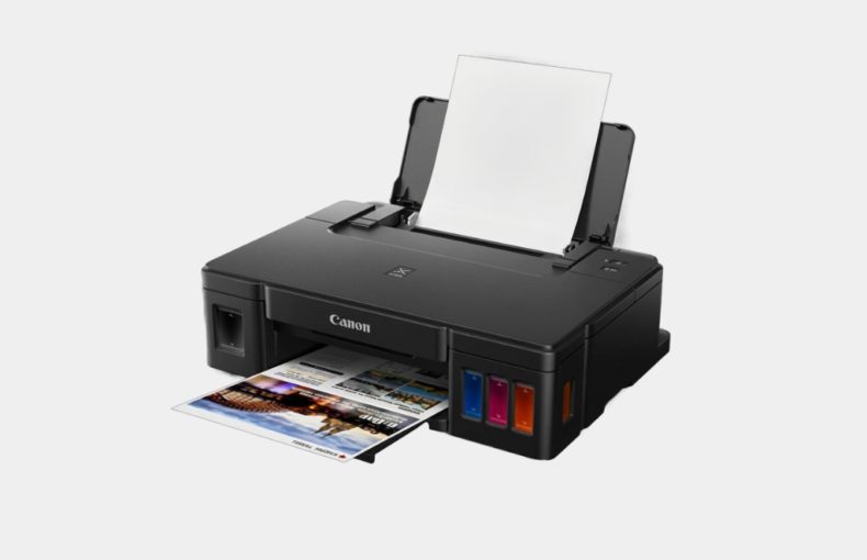Canon PIXMA ink tank printer with visible cyan, magenta and yellow ink tanks printing a colour photo