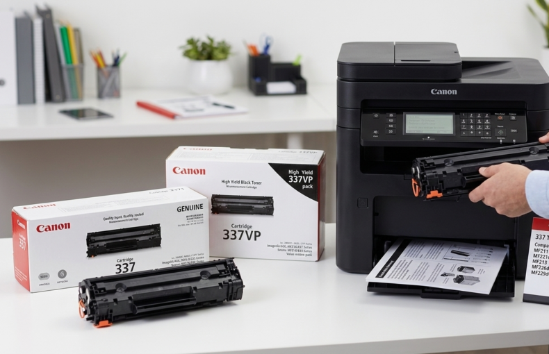 Canon Cartridge 337 and 337VP toner boxes on a desk while a person installs a cartridge into a Canon MF200 series printer