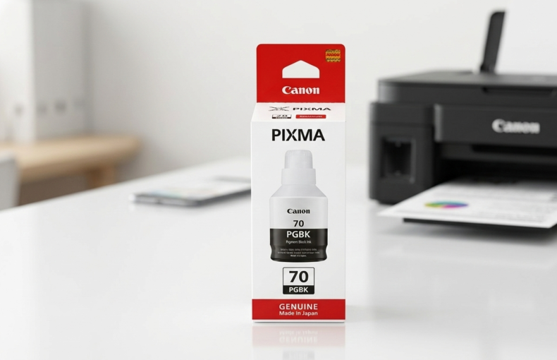 Canon PIXMA GI-70 PGBK black ink bottle box on a desk with a Canon printer in the background